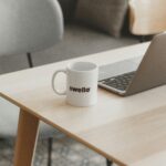 a white coffee mug sitting on top of a wooden table