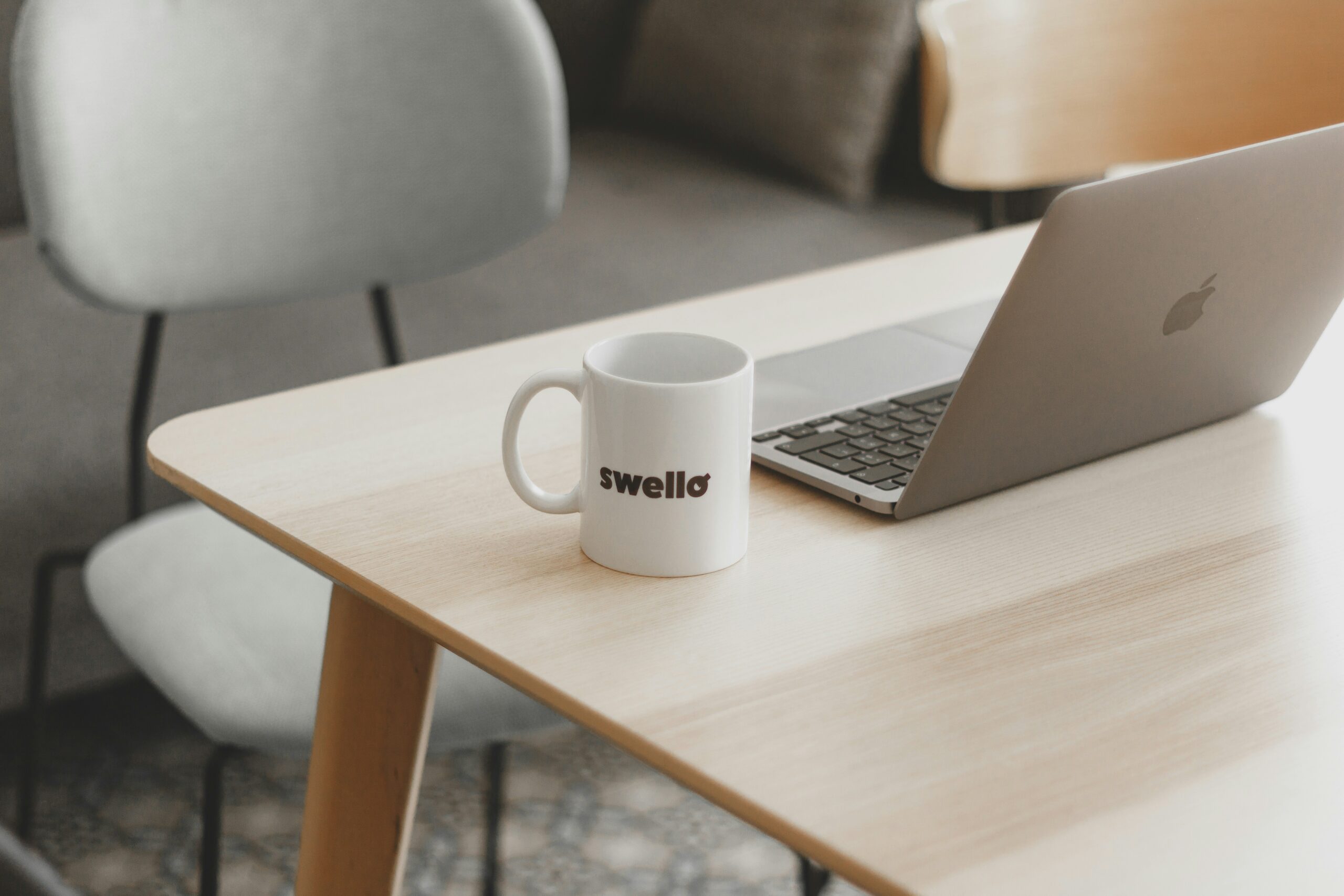 a white coffee mug sitting on top of a wooden table