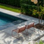 a couple of lawn chairs sitting next to a pool
