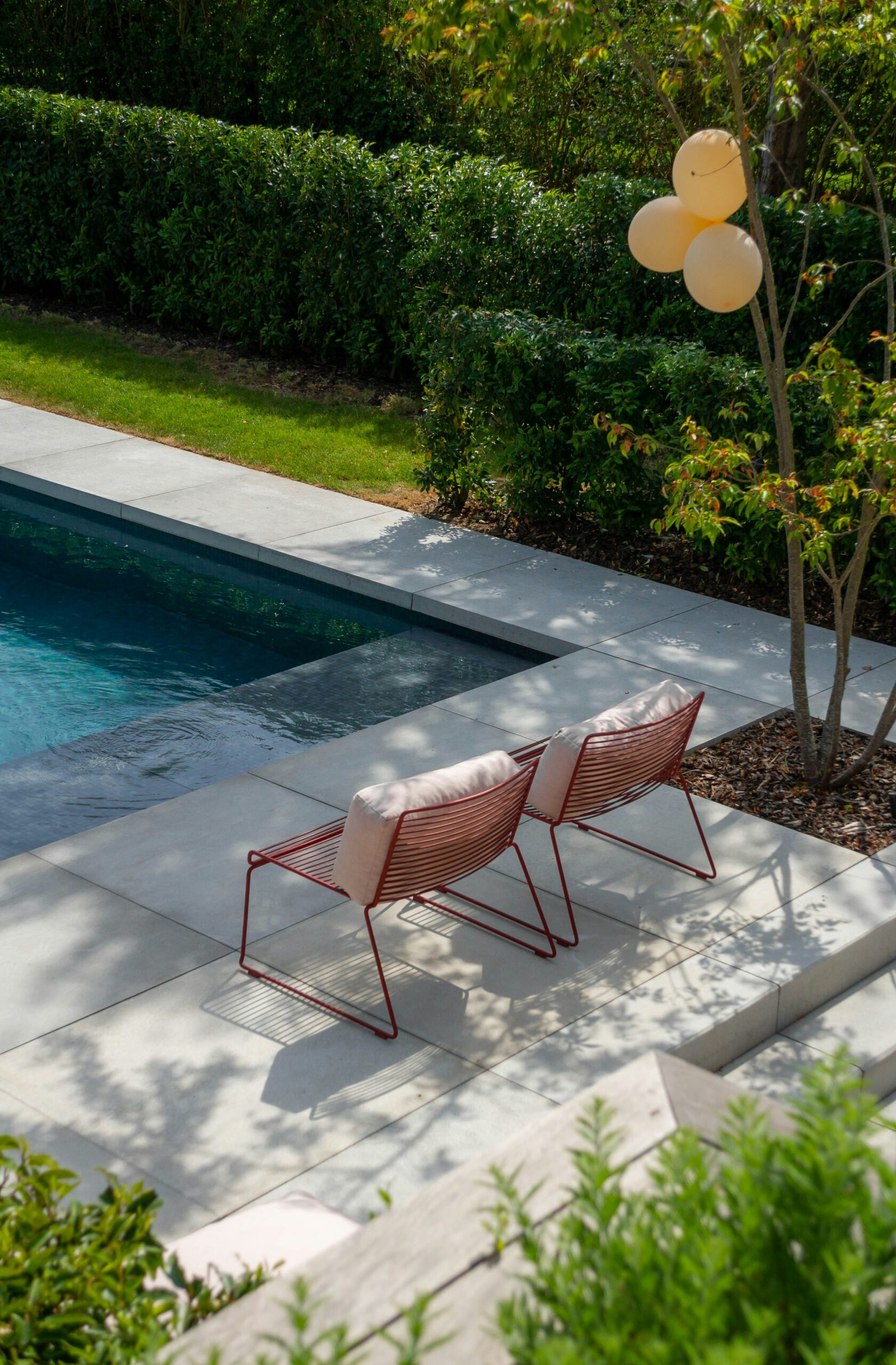 a couple of lawn chairs sitting next to a pool